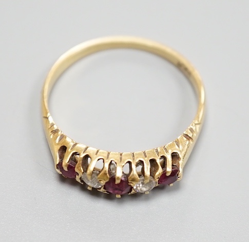 An 18ct three stone ruby and two stone diamond set half hoop ring, size P, gross 2.9 grams.